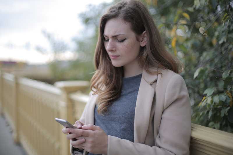 Pensive woman with phone